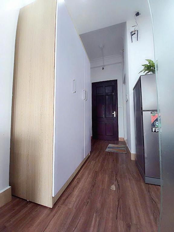 an empty room with wooden floors and a door at Chỗ nghỉ cuối tuần in Hanoi