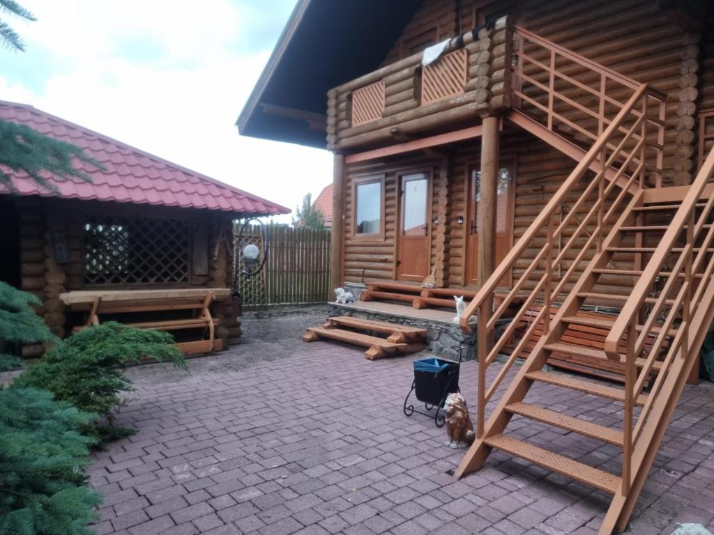 a log cabin with a staircase next to a patio at Бухта Вікінга in Szack