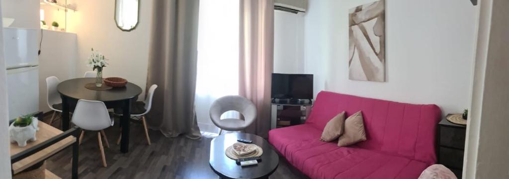 a living room with a pink couch and a table at Coco Apartment in Dobrota
