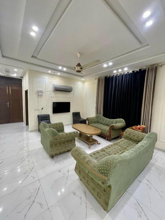 费萨拉巴德Elysian Nest 2BR Apartment Abdullah Gardens的带沙发和桌子的大客厅