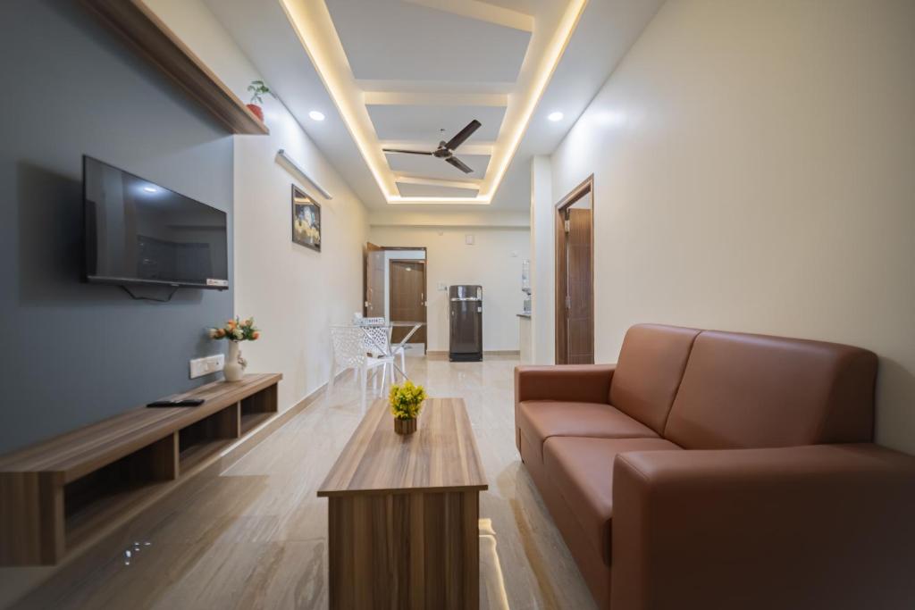 a living room with a couch and a tv at Stayhomestays Grande in Bangalore