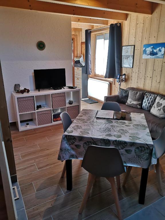 un salon avec une table et un canapé dans l'établissement Appartement à la montagne, à Villar-dʼArêne