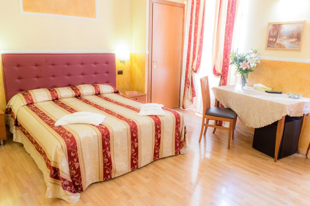 a hotel room with a bed and a table and a table at Residenza Ki in Rome