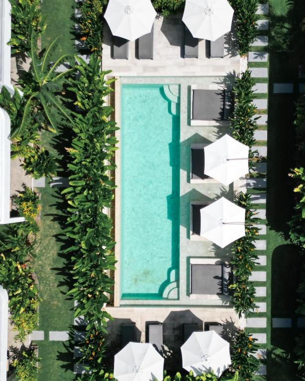 セロング・ベラナクにあるAmazing Lombok Resortのパラソル付きのスイミングプールのオーバーヘッドビュー