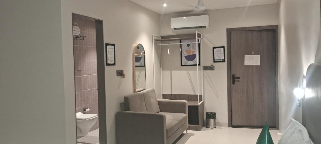 a hospital room with a chair and a door at Shine Hospitality Boutique Hotel in Mumbai