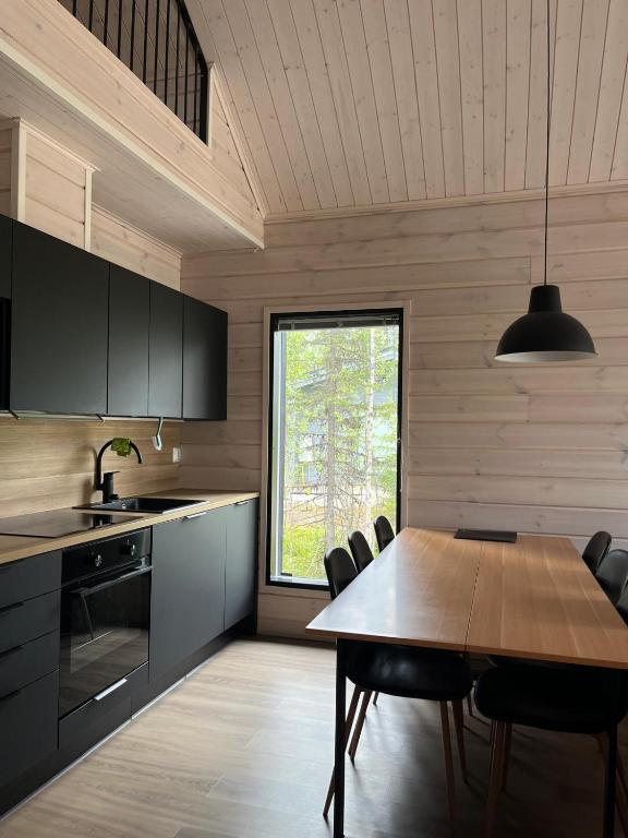 a kitchen with a table and chairs and a window at Villa Luokka, Iso-Syöte in Syöte