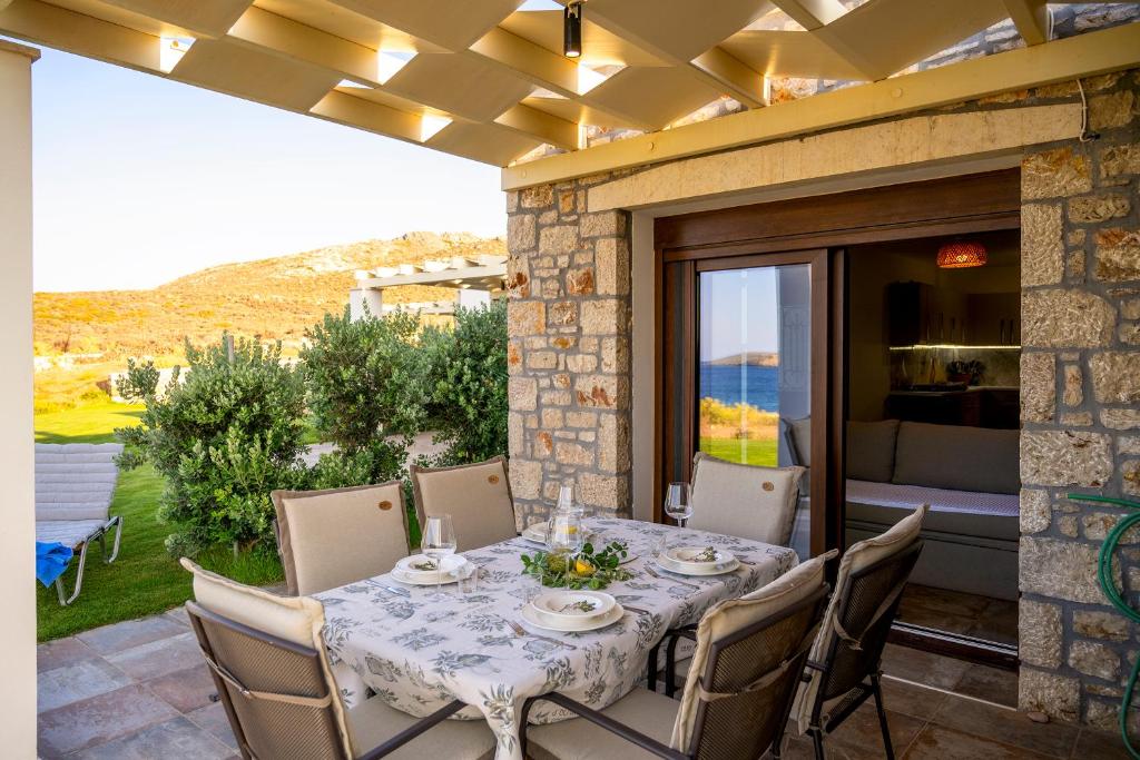 Une table à manger et des chaises sont disponibles sur la terrasse. dans l'établissement Kavo Plako Studio 1, à Palekastro