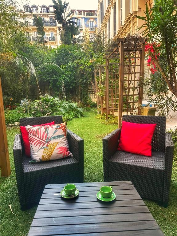 deux chaises et une table avec des tasses vertes dessus dans l'établissement Homelivia, Luxueux Appartement avec Jardin privé, à Nice
