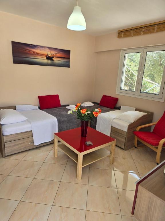 a room with two beds and a table with flowers at La Sirenetta Residence in Sivota