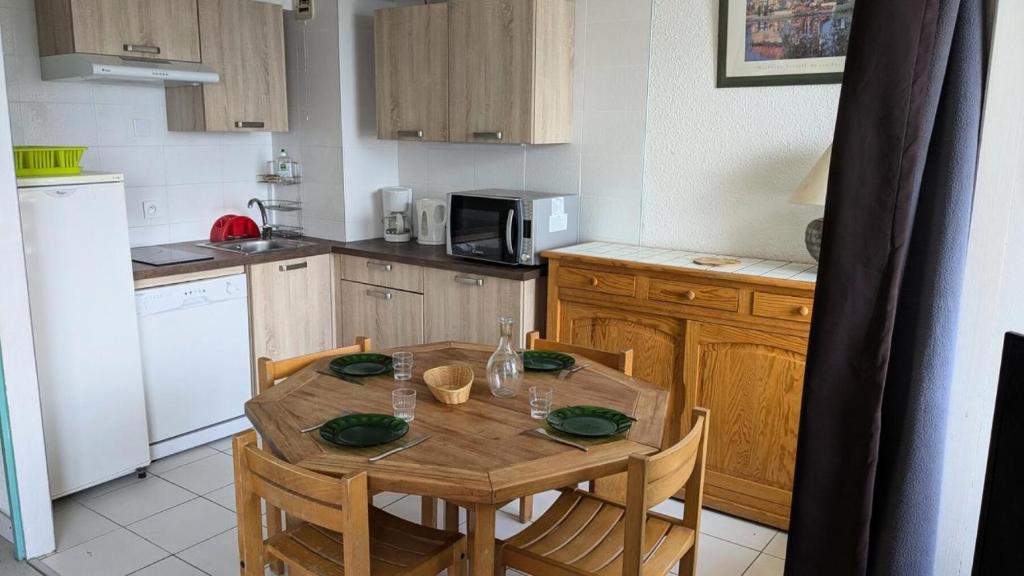 une cuisine avec une table en bois, des chaises, une table et une table dans l'établissement Résidence Rond-point-pistes I - Trois pièces 8 pers. au rond point des pistes 1 n° 58 A - MAE-7064, à Orcières