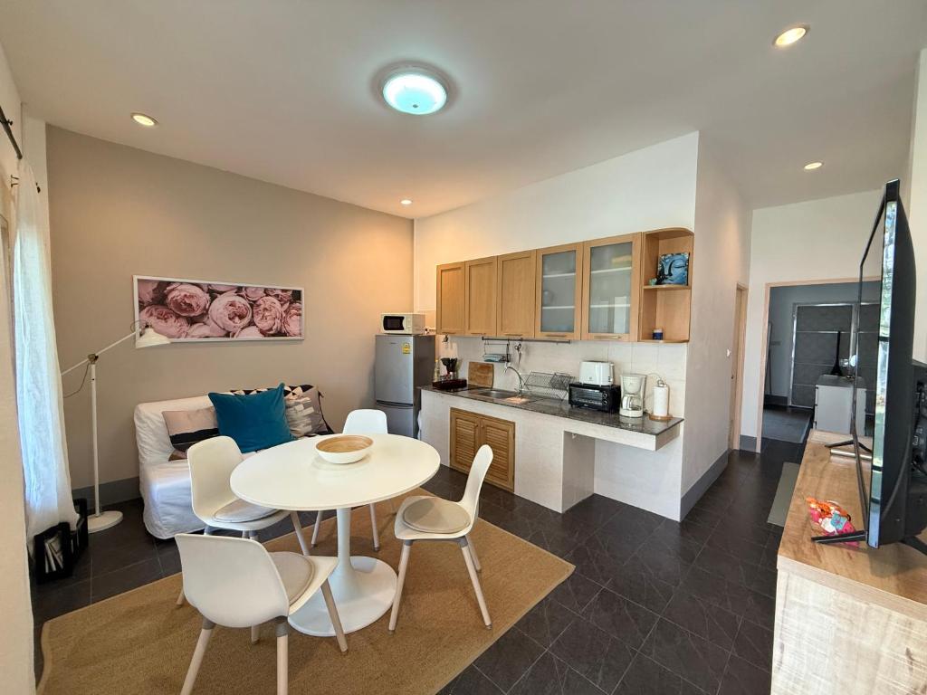 een keuken en een woonkamer met een tafel en stoelen bij Tropical 1 Bedroom Pool House In Central Location in Hua Hin