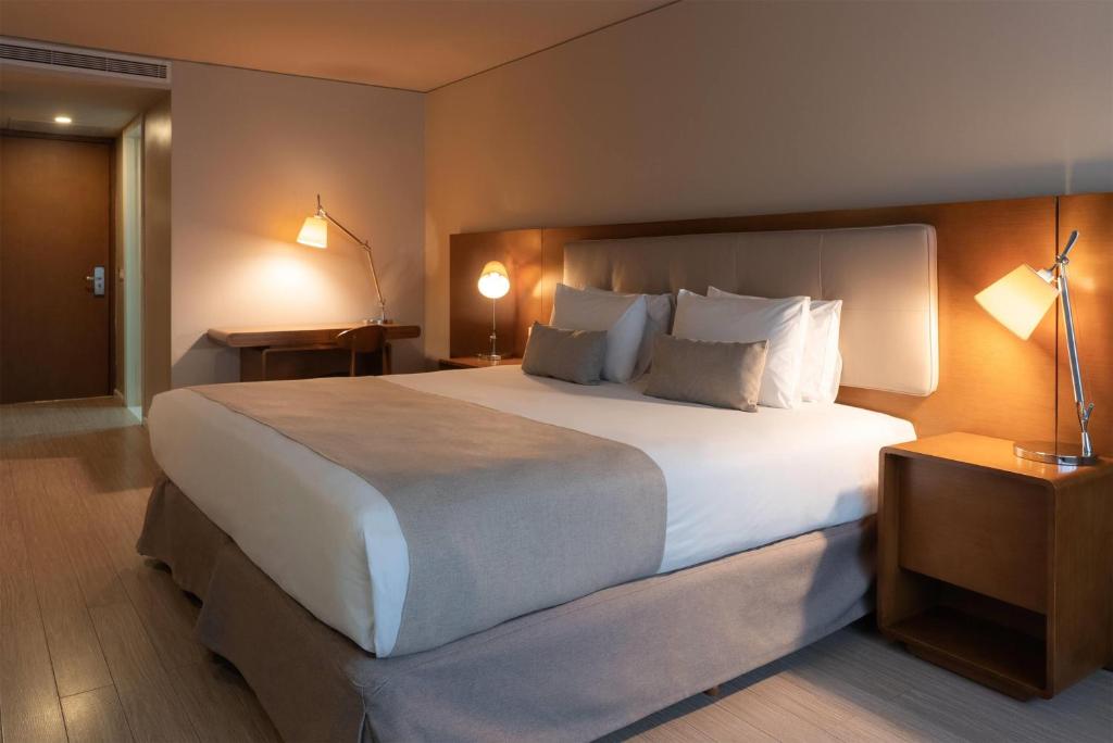 a bedroom with a large bed with white sheets and pillows at Dazzler by Wyndham Montevideo in Montevideo