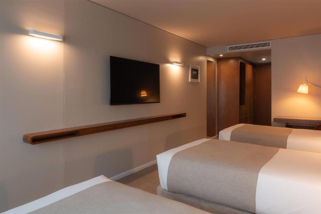 a hotel room with two beds and a flat screen tv at Dazzler by Wyndham Montevideo in Montevideo
