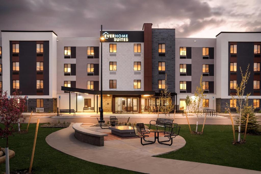 a hotel building with a courtyard with tables and chairs at Everhome Suites Bozeman in Bozeman