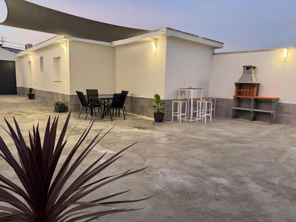 Un patio con sillas negras y una mesa en un edificio. en Villa dos Soles, en Vejer de la Frontera