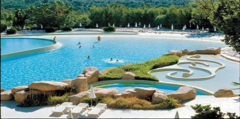 - une piscine dans un complexe avec des personnes qui s'y baignent dans l'établissement La Cigale, à Grimaud