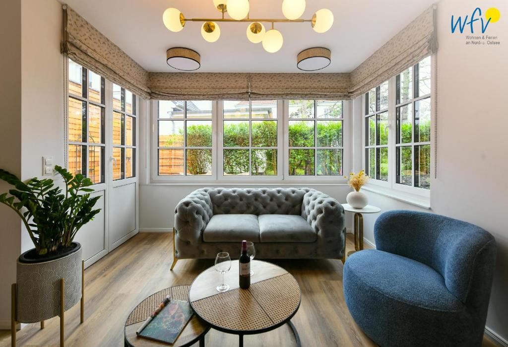 a living room with a couch and two chairs at Haus Casper Ferienwohnung 2 in Langeoog