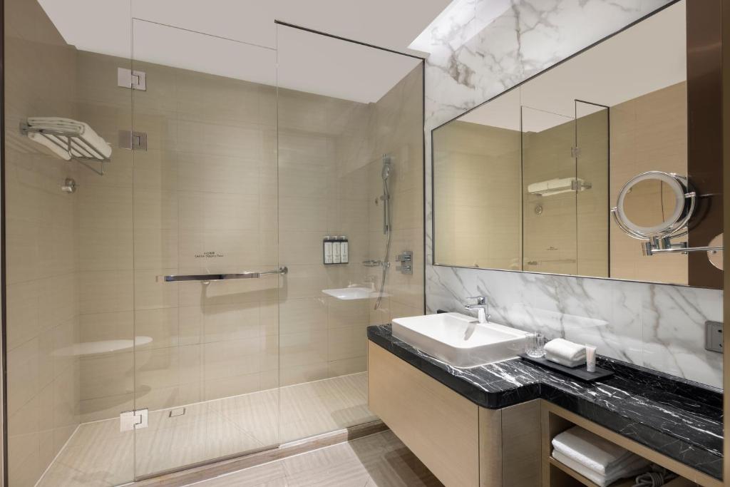a bathroom with a sink and a shower and a mirror at Hyatt House Shanghai Hongqiao CBD in Shanghai