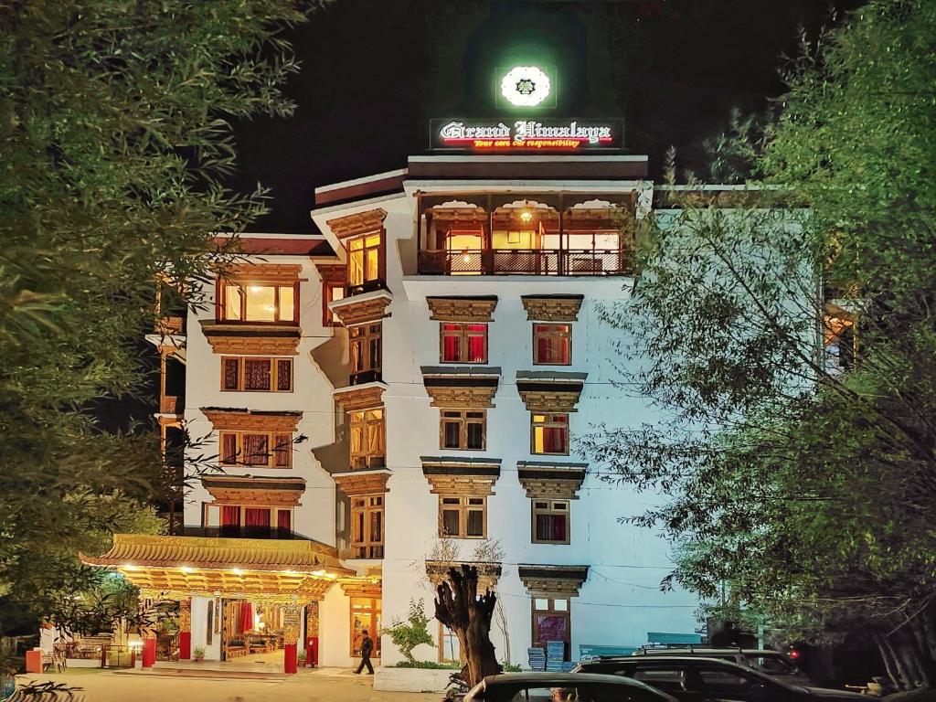 a tall white building with a clock on top of it at Hotel Grand Himalaya in Leh