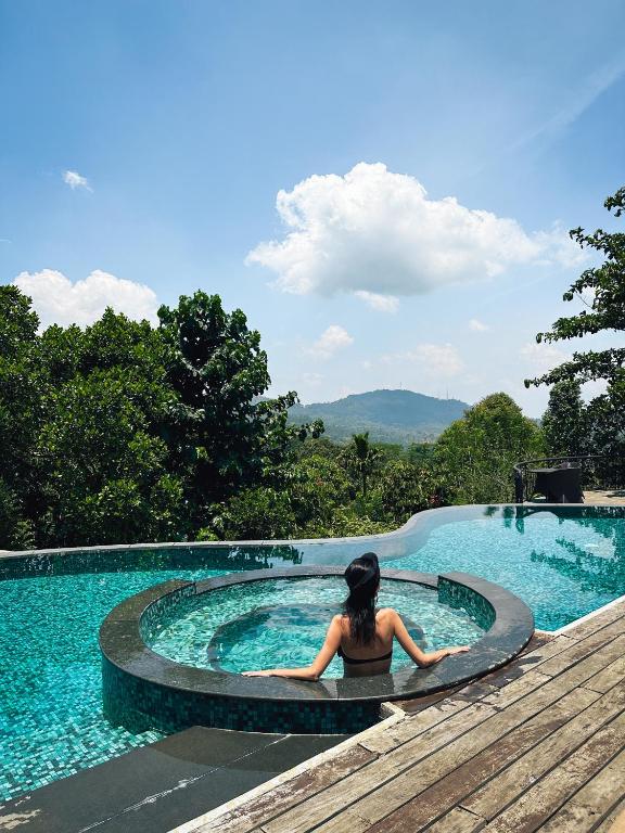a woman sitting in a swimming pool at Kandy Dendrobium House in Kandy