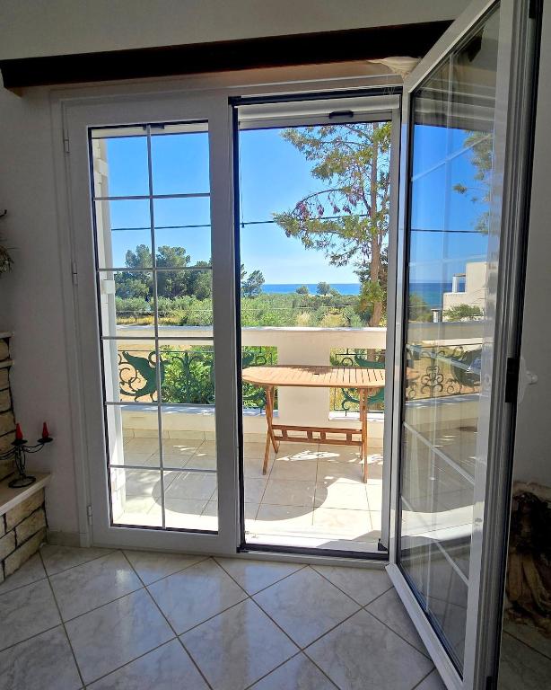 a sliding glass door leading to a patio with a table at Annie's summer house in Plytra