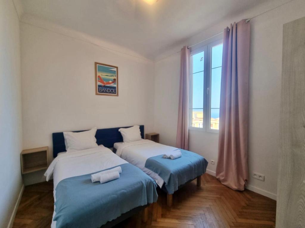 ein Schlafzimmer mit zwei Betten und einem großen Fenster in der Unterkunft Villa Clair LOGIS MONACO Parking Terrasse in Beausoleil