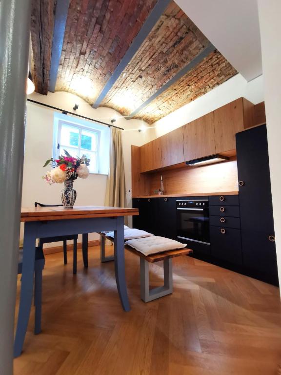 a kitchen with a table with a vase of flowers on it at La Maison Monsieur Mathieu in Rothenburg ob der Tauber