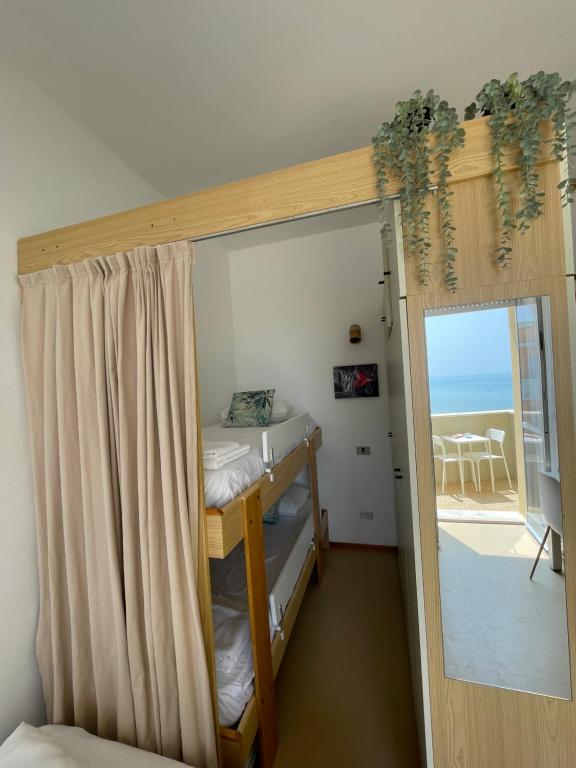 een kamer met 2 stapelbedden en een glazen schuifdeur bij Apartament Mare e Sole z basenem i przy plaży in Marotta