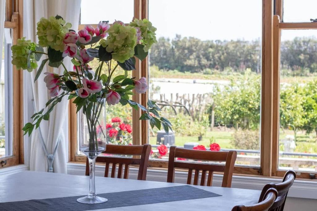 a vase of flowers on a table in front of a window at The Homestead - a rural family retreat in Sentry Hill
