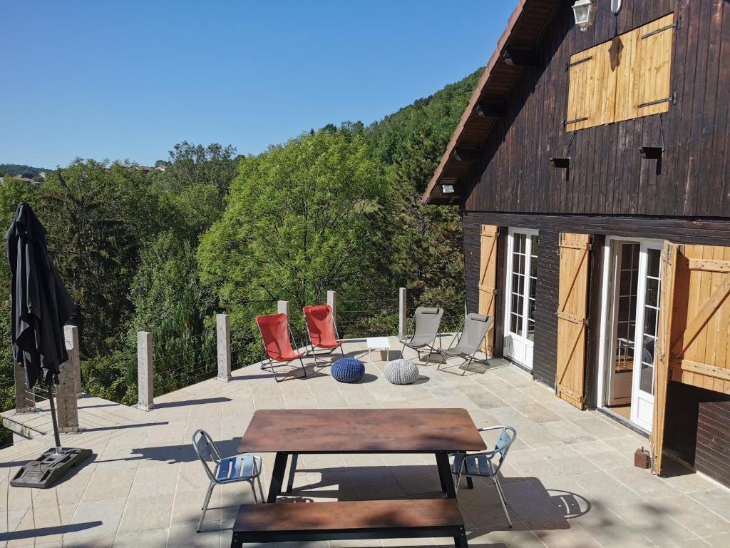 Serrières-sur-AinにあるLe Chalet D'en Paradisのパティオ(椅子、テーブル付)