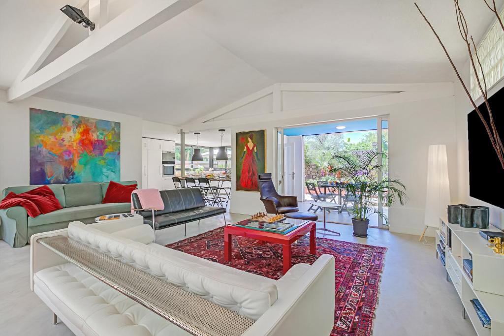 - un salon doté d'un mobilier blanc et d'un tapis rouge dans l'établissement Antibes Loft Retreat - Happy Rentals, à Juan-les-Pins