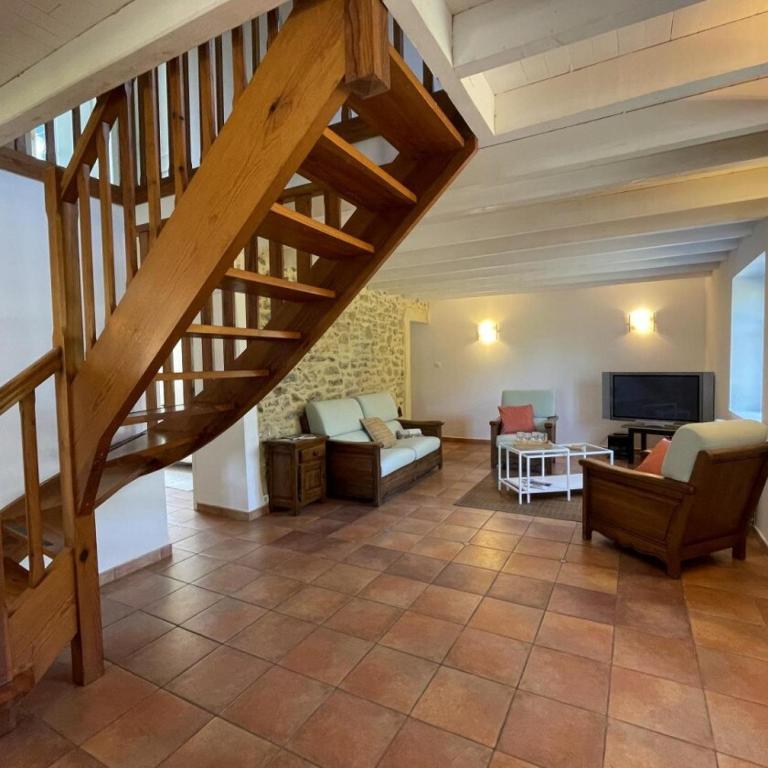 - un salon avec un escalier en bois dans l'établissement Gite Des Cimes, à Baigts-de-Béarn