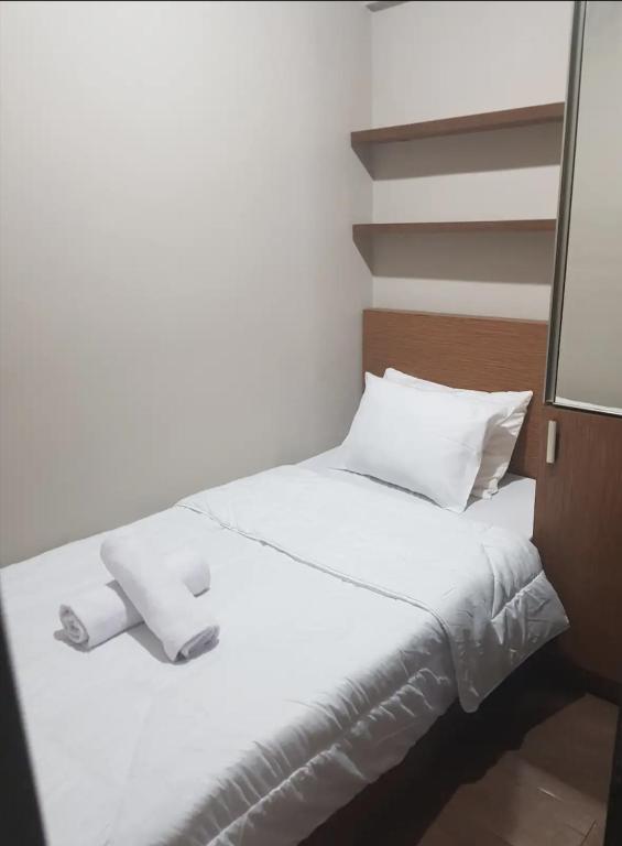 a white bed with two rolls of towels on it at Jardin B20, Pool View, Netflix & WIFI in Bandung