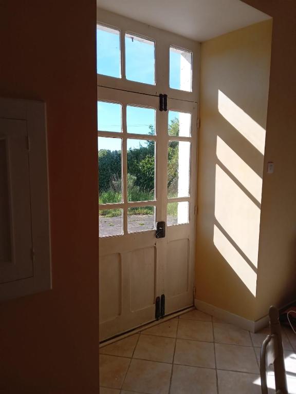 une chambre vide avec une porte et une fenêtre dans l'établissement LES VOLETS VERTS 'The Green Shutters', à Roussines