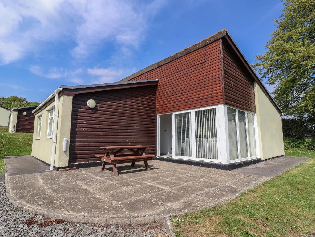 a small cabin with a bench in front of it at Harcombe House Accessible Pet Free Bungalow Sleeps 6 in Newton Abbot