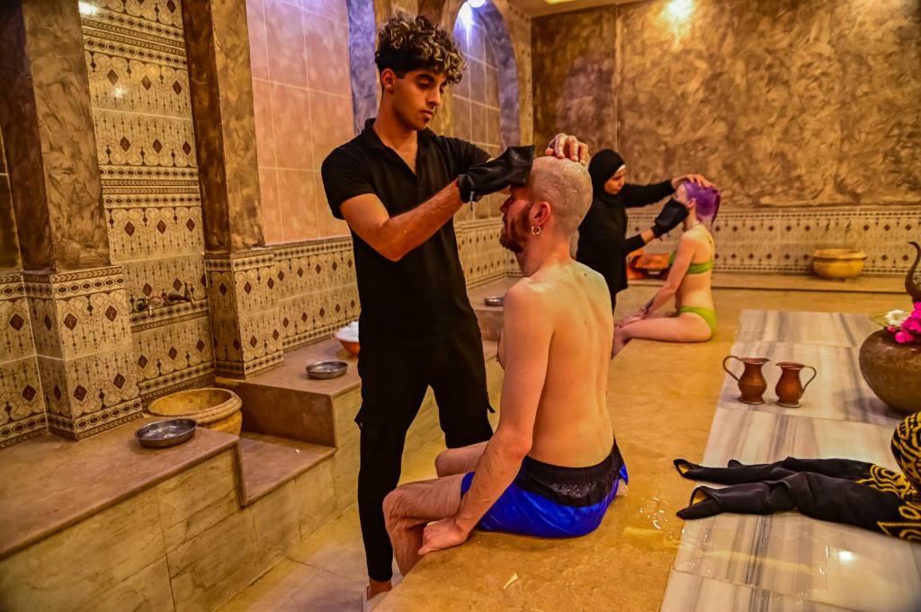 a man cutting another mans hair in a barber shop at Eagles Spa in Hurghada