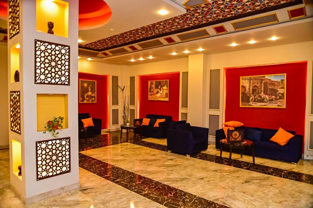a living room with red walls and blue couches at Eagles Spa in Hurghada