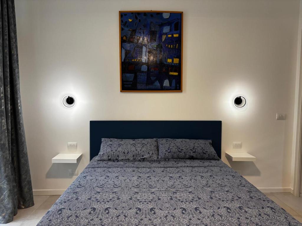 1 dormitorio con 1 cama azul y 2 mesas en La mia Griona, en Vigevano