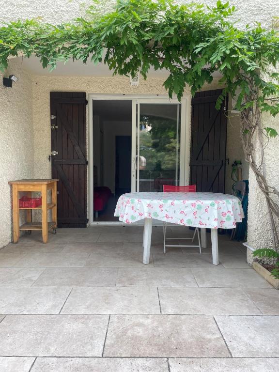 - une table avec un tissu de table floral sur la terrasse dans l'établissement Studio Fontsainte Terrasse Parking Clim Proche Mer, à La Ciotat