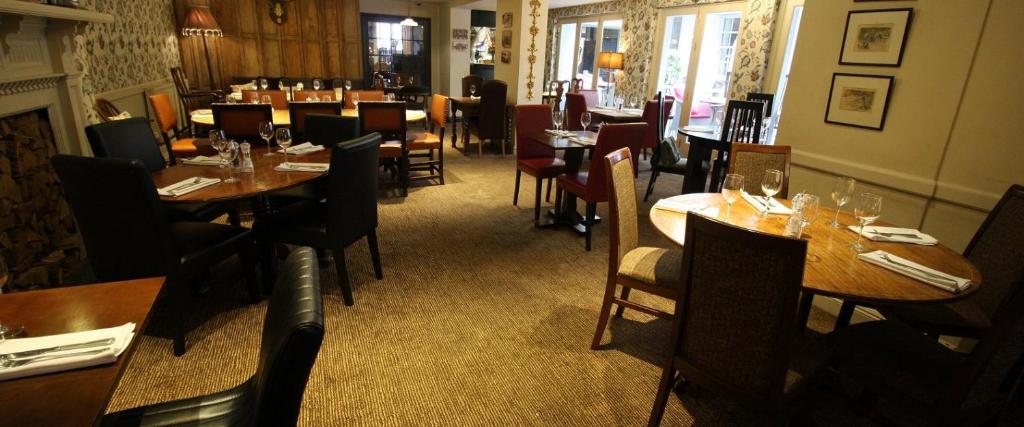 a restaurant with tables and chairs in a room at The Bear Hotel in Wantage