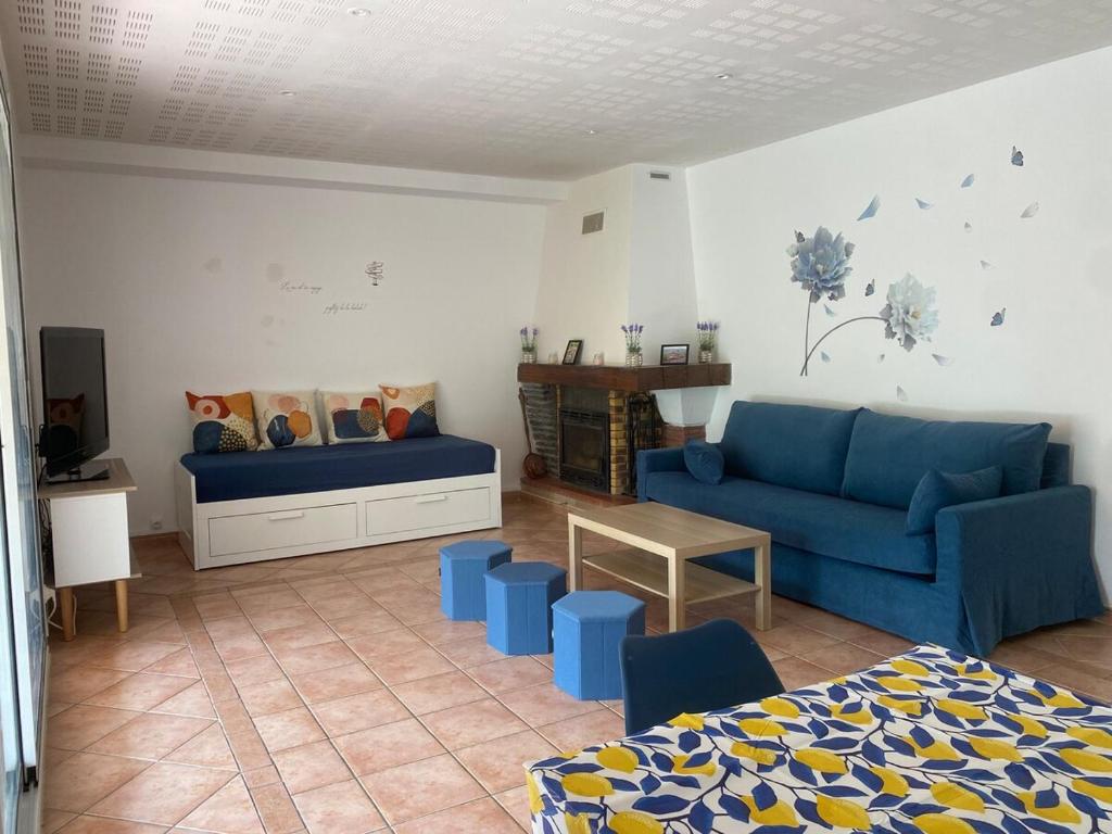 un salon avec un canapé bleu et une table dans l'établissement Maison 8 couchages avec piscine, à Forcalquier