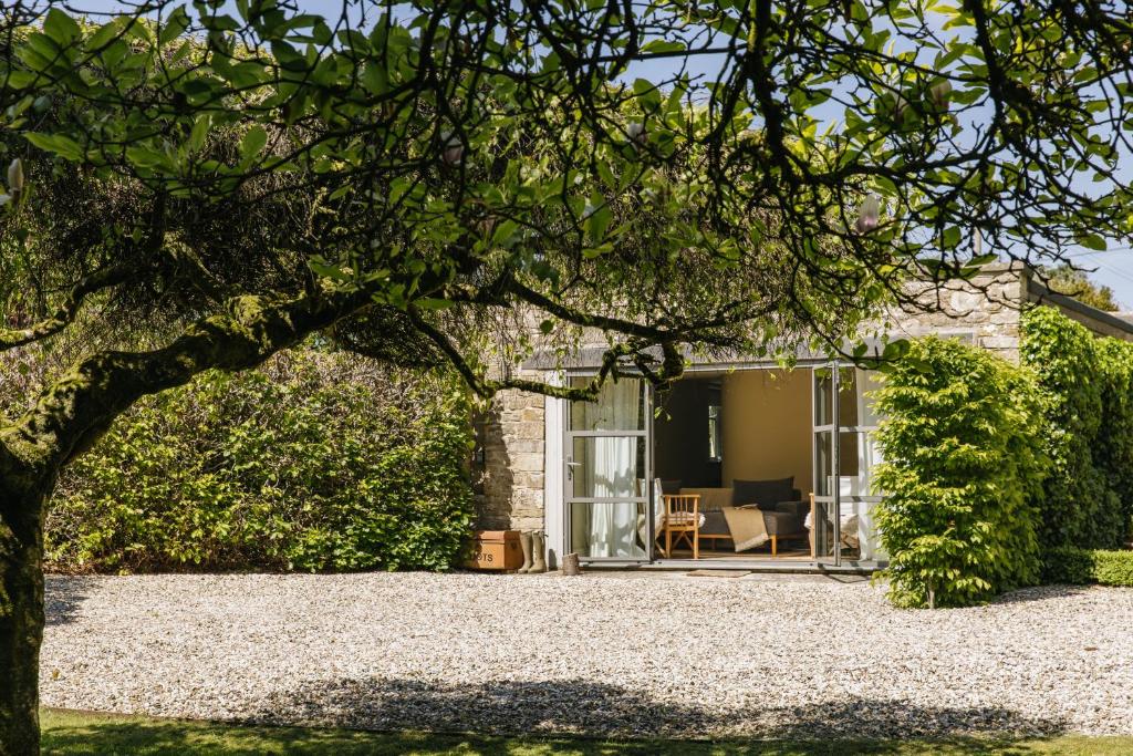 a house with a patio and a tree at A Luxury Retreat in the Cotswolds in Cheltenham