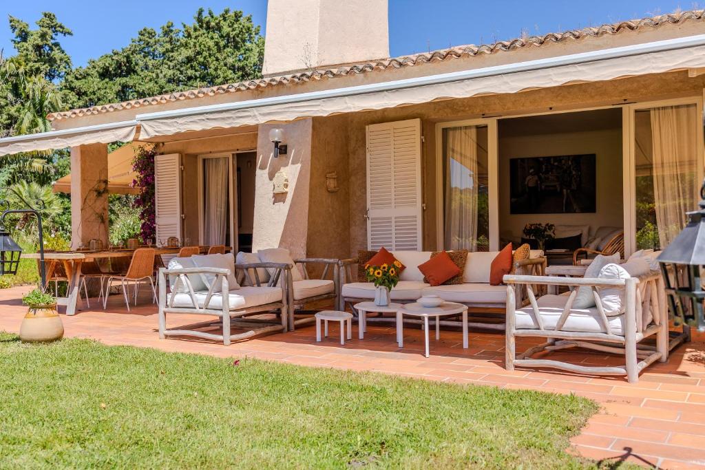 un patio avec des chaises, un canapé et une table dans l'établissement Villa les Vignes Basses - Saint Tropez, à Saint-Tropez