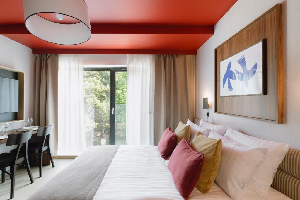 1 dormitorio con 1 cama grande y techo rojo en Ironique by MB Apartments, en Cracovia