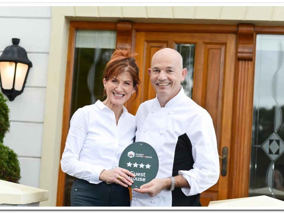 a man and a woman are holding a award at Brooke Lodge Guesthouse in Magherafelt