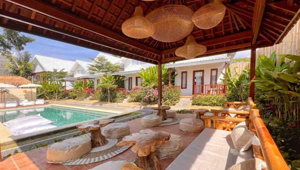 an outdoor patio with a swimming pool and a house at Bacana Bungalow in Uluwatu