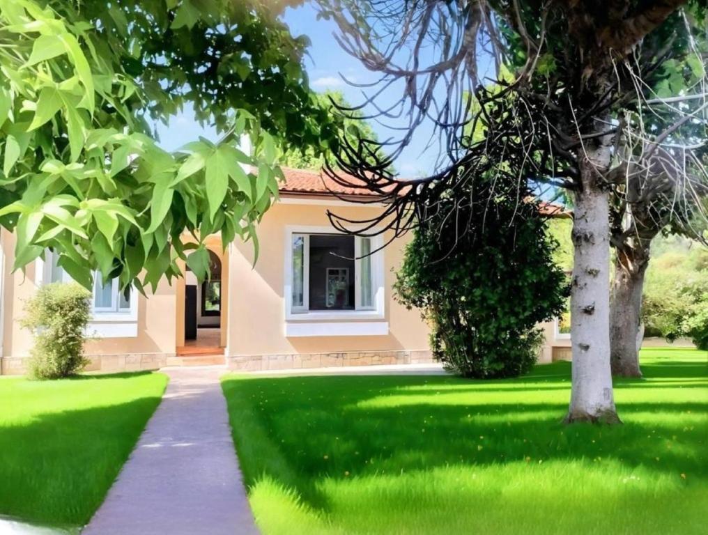 une maison avec une pelouse verte et une passerelle dans l'établissement La maison familiale, à Le Porge