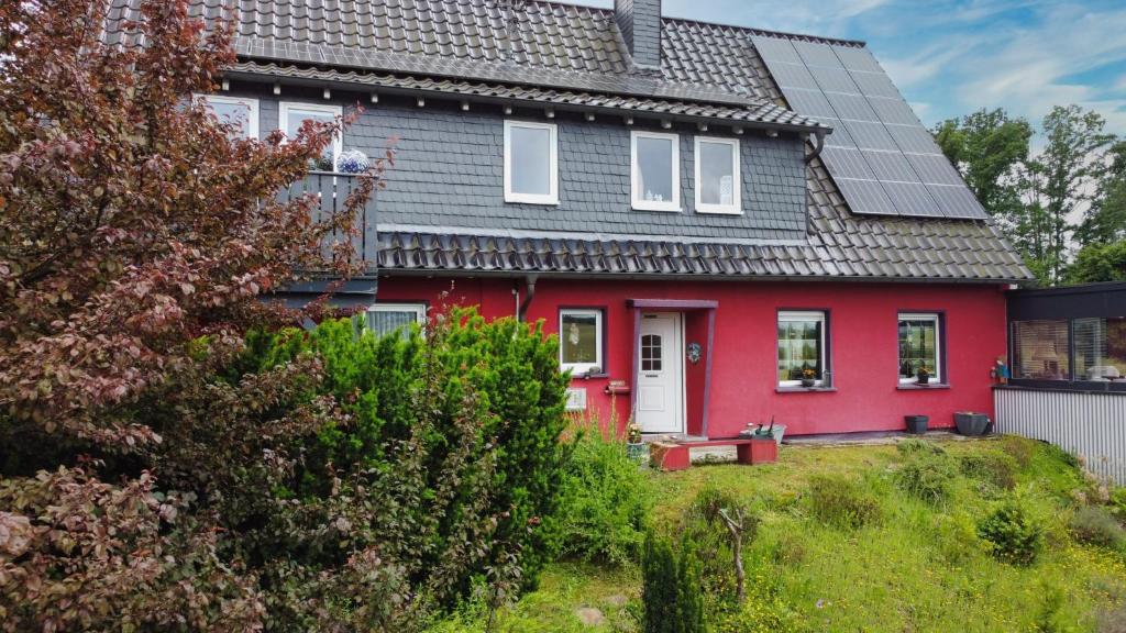 a red house with a gray roof at Haus Hönigblick in Wilnsdorf