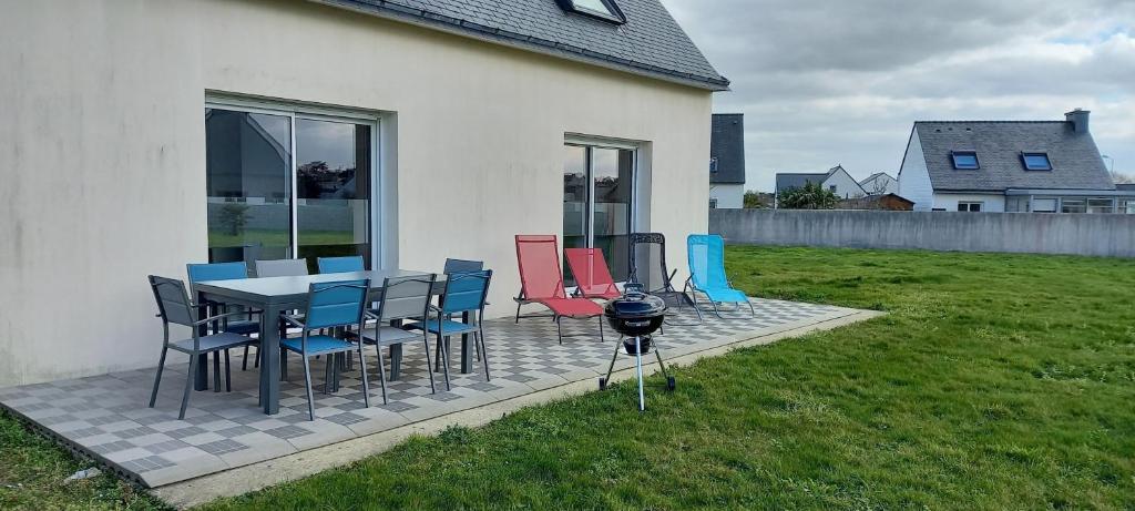 un patio avec une table, des chaises et un barbecue dans l'établissement Gîte Portsallais, à Ploudalmézeau