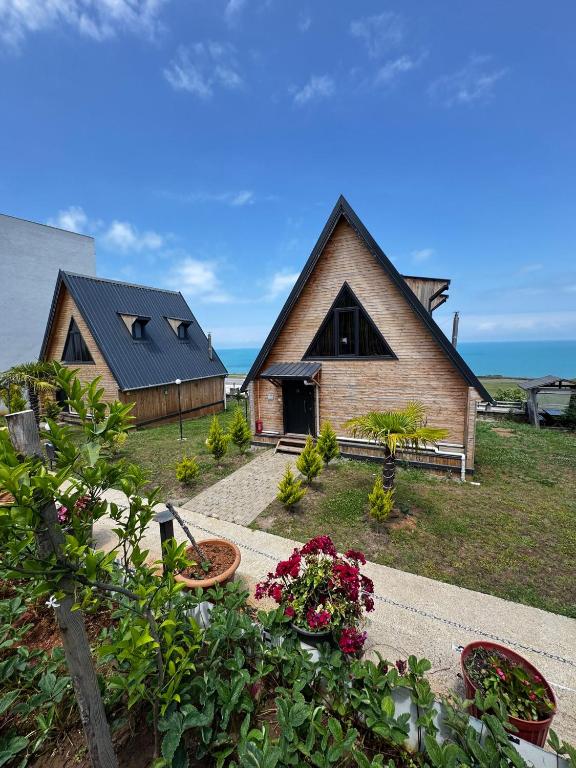 a house with a garden and flowers in front of it at Azhara Bungalow in Soğuksu
